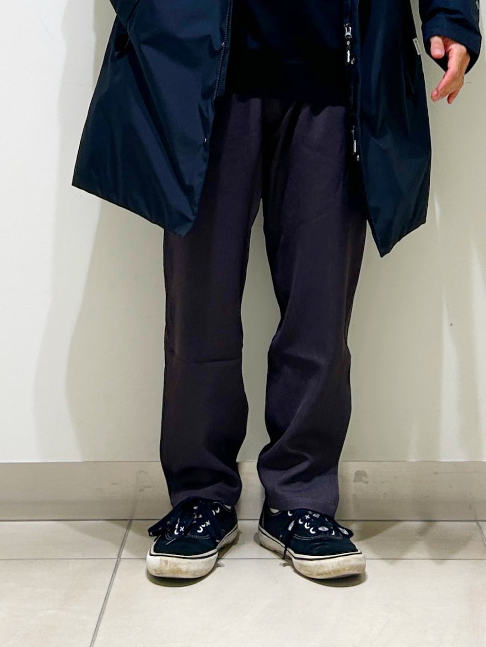 ブラック系のニット/セーター、ブラック系のダウンジャケット/コート、グレー系のスラックスを着用したメンズの秋コーディネートの10枚目の写真