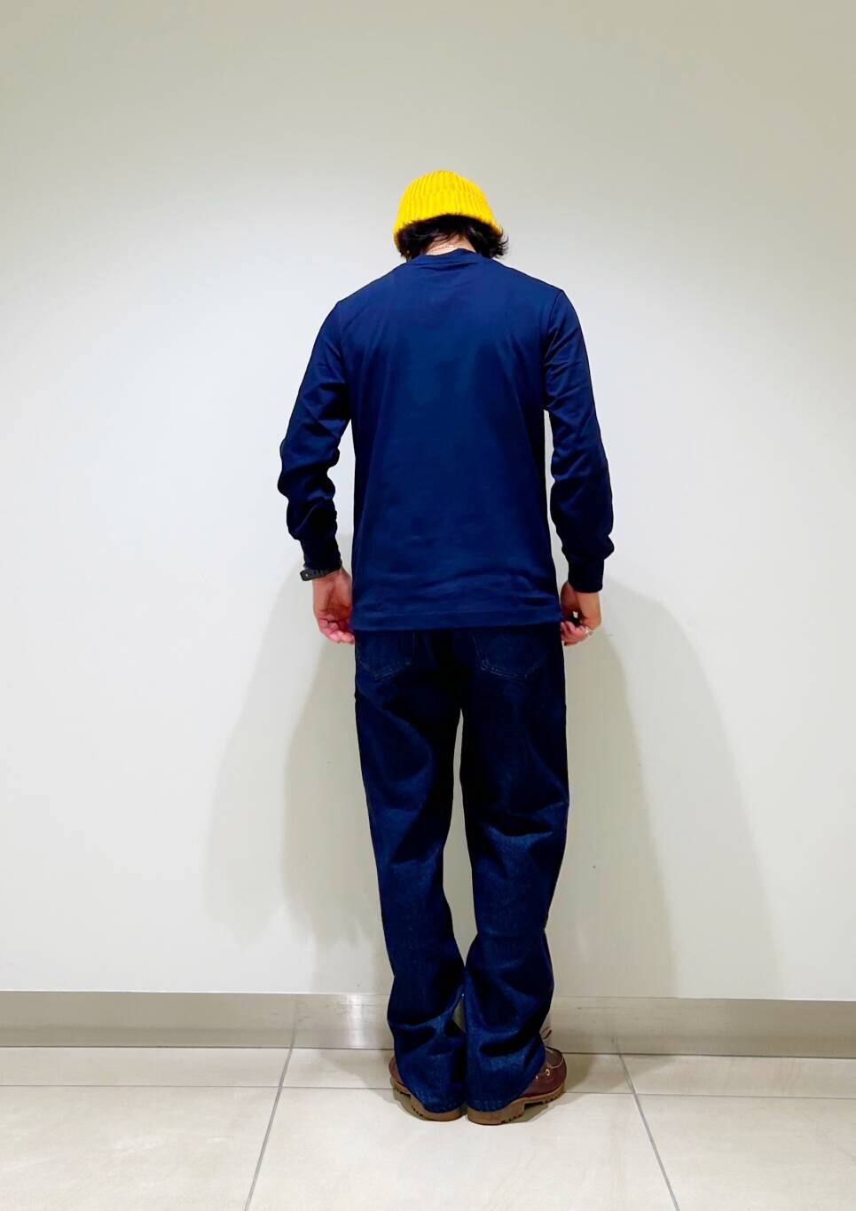 ブルー系のデニムパンツ、ブルー系のTシャツ/カットソー、イエロー系のニットキャップ/ビーニーを着用したメンズの秋コーディネートの7枚目の写真