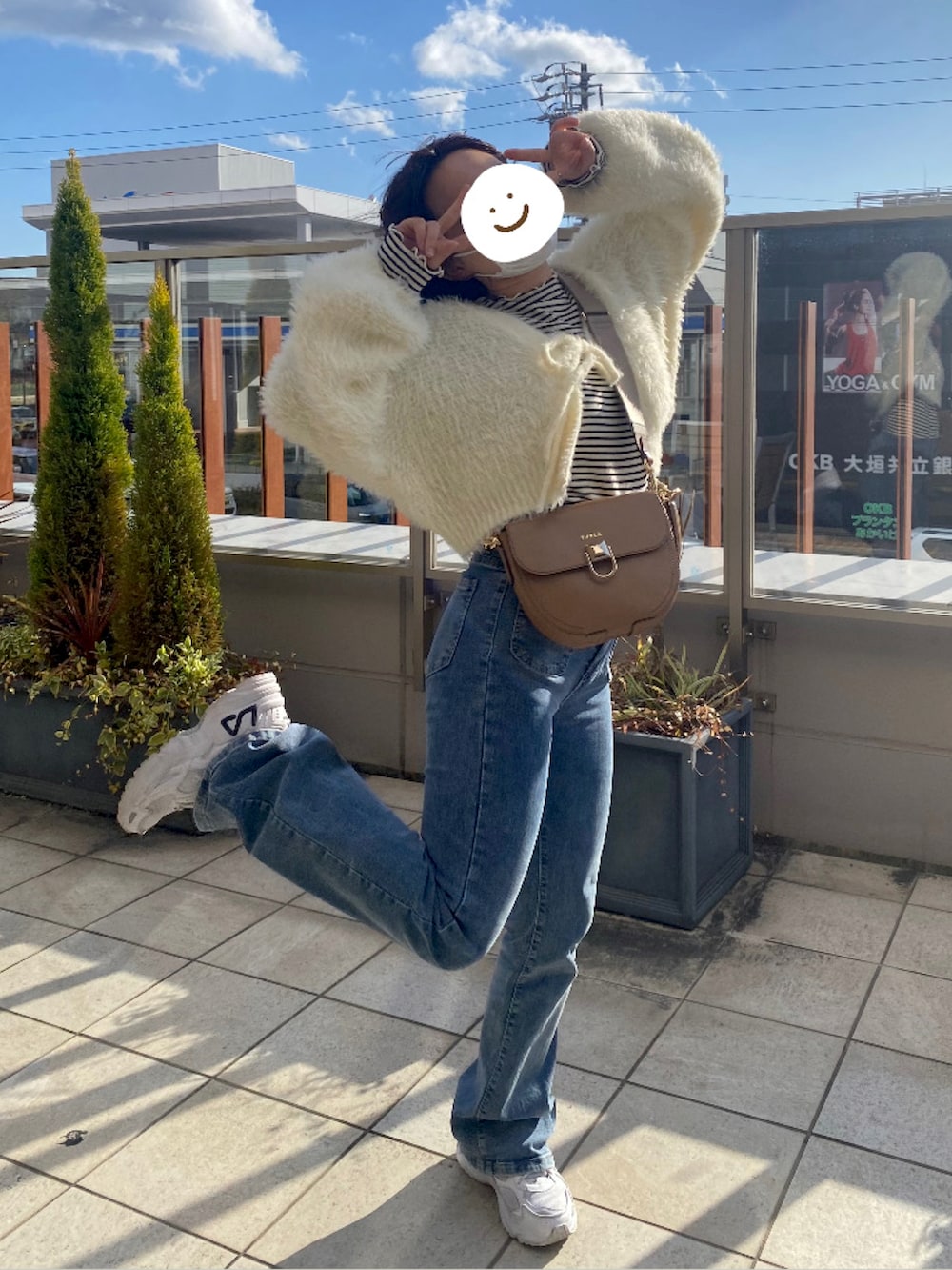 イエロー系のカーディガン/ボレロ、ベージュ系のバッグ、ブラック系のTシャツ/カットソーを着用したレディースの春コーディネートの2枚目の写真