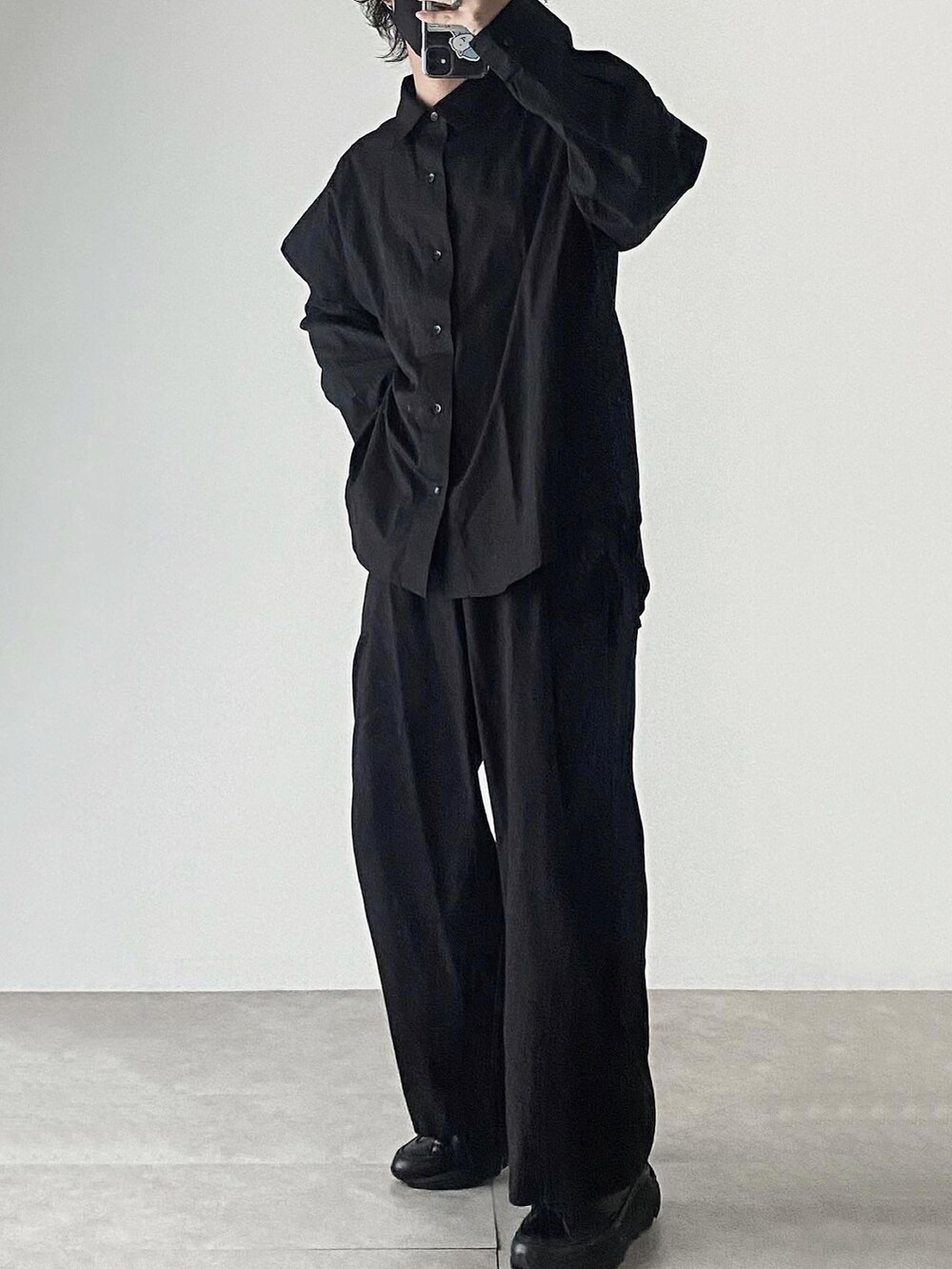 ブラック系のシャツ/ブラウス、ブラック系のスラックス、ブラック系のスニーカーを着用したメンズの秋コーディネートの2枚目の写真