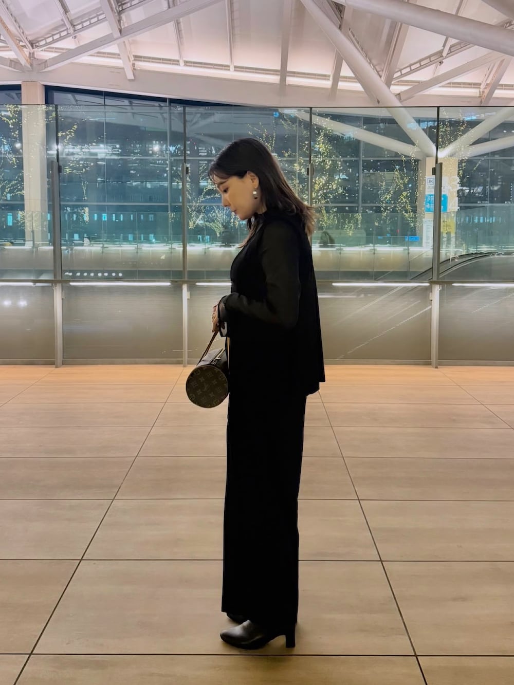 ブラック系のスーツセットを着用したレディースの冬コーディネートの6枚目の写真