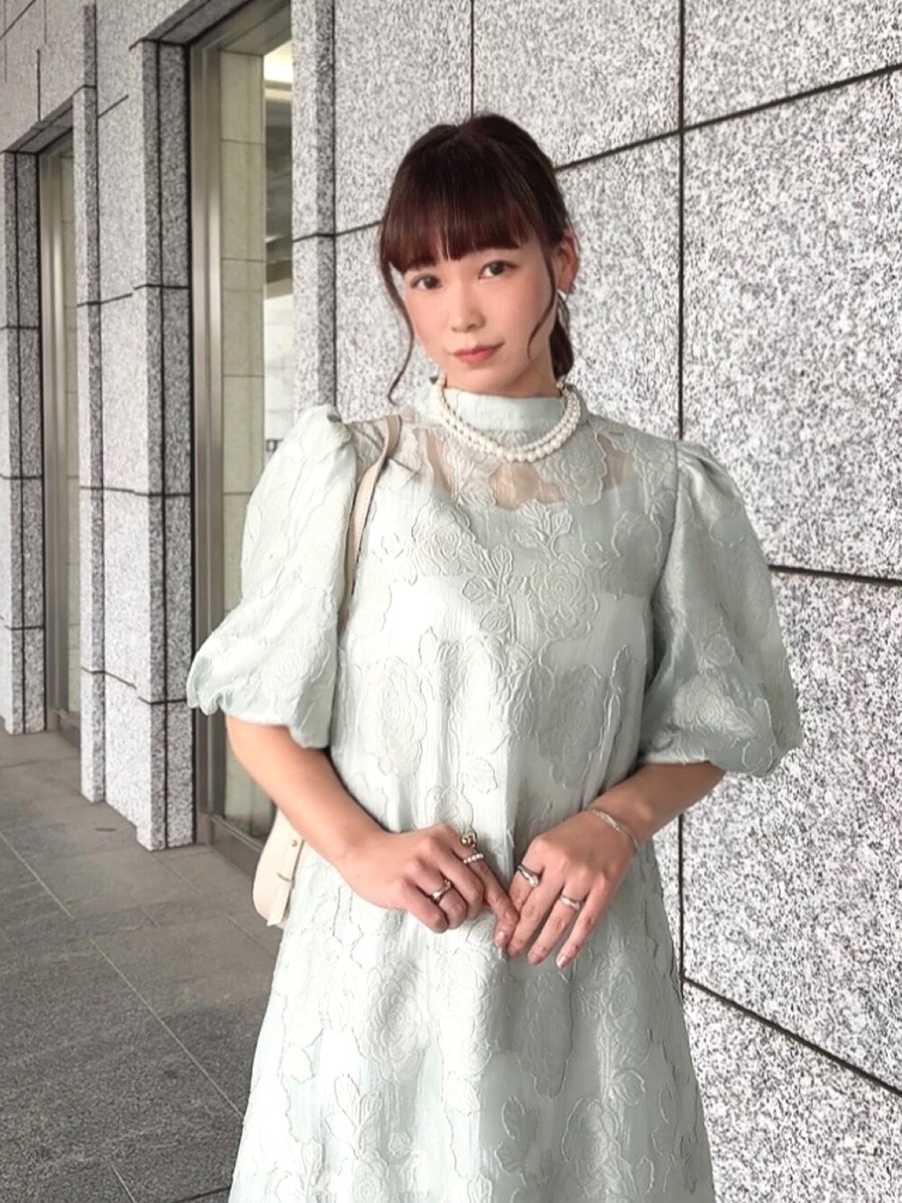 グリーン系のドレスを着用したレディースの春コーディネートの2枚目の写真