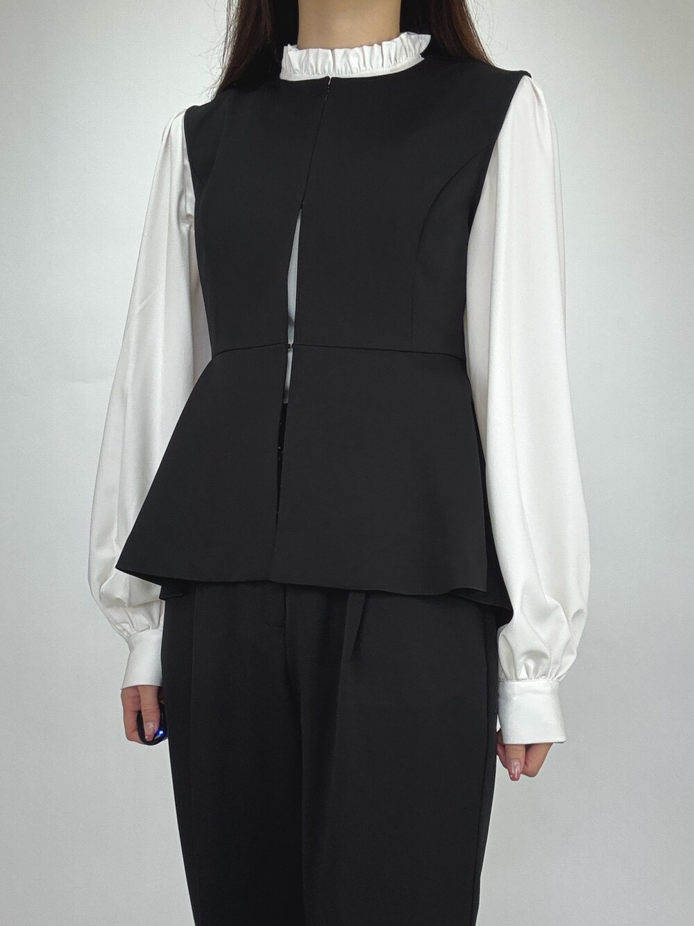 ブラック系のスーツセットを着用したレディースの冬コーディネートの2枚目の写真