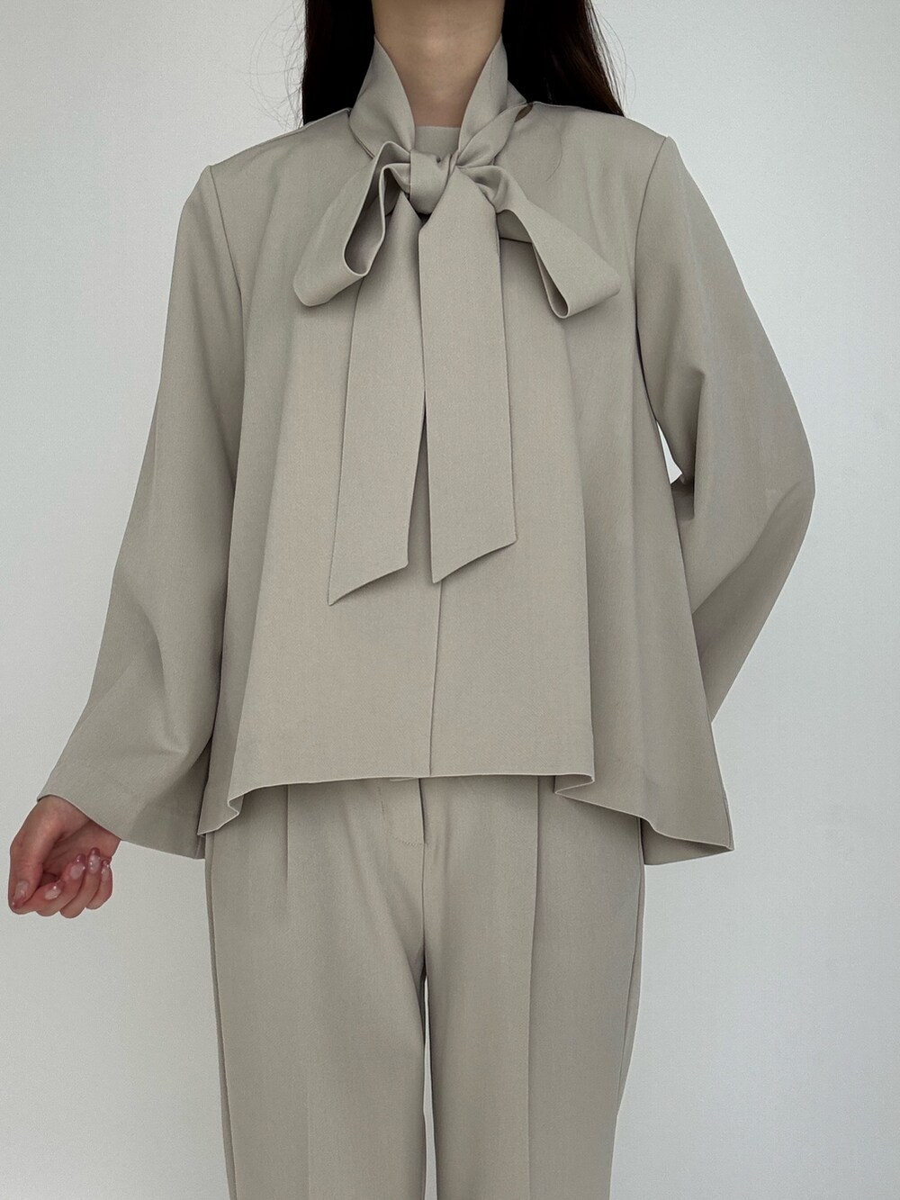 ベージュ系のスーツセットを着用したレディースの冬コーディネートの6枚目の写真