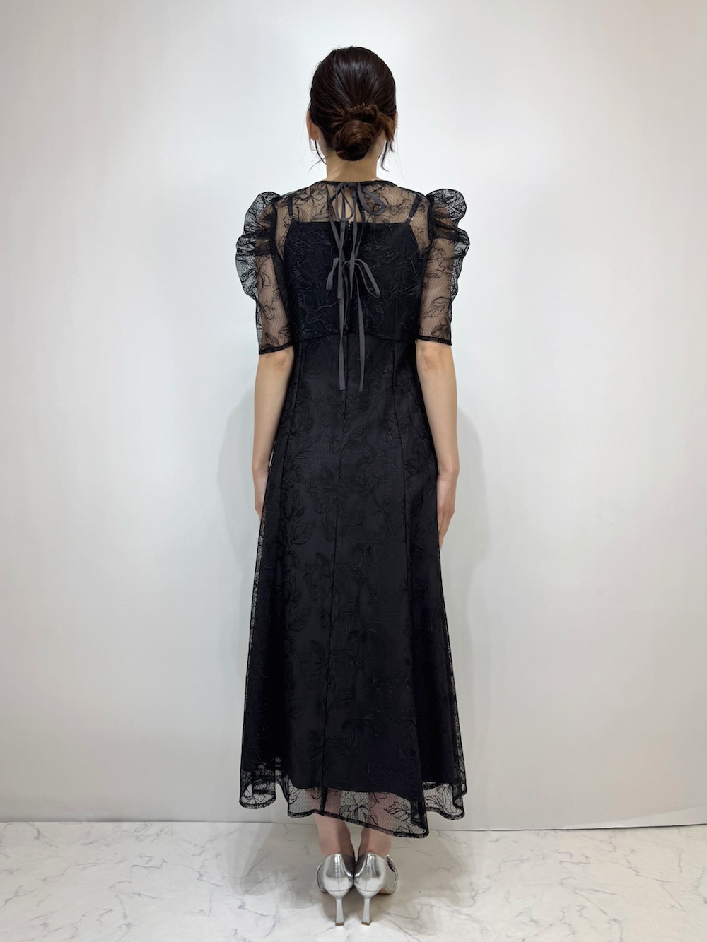 ブラック系のドレス、シルバー系のパンプスを着用したレディースの冬コーディネートの2枚目の写真