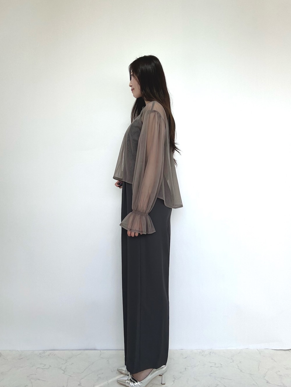 グレー系のドレス、シルバー系のパンプスを着用したレディースの秋コーディネートの2枚目の写真