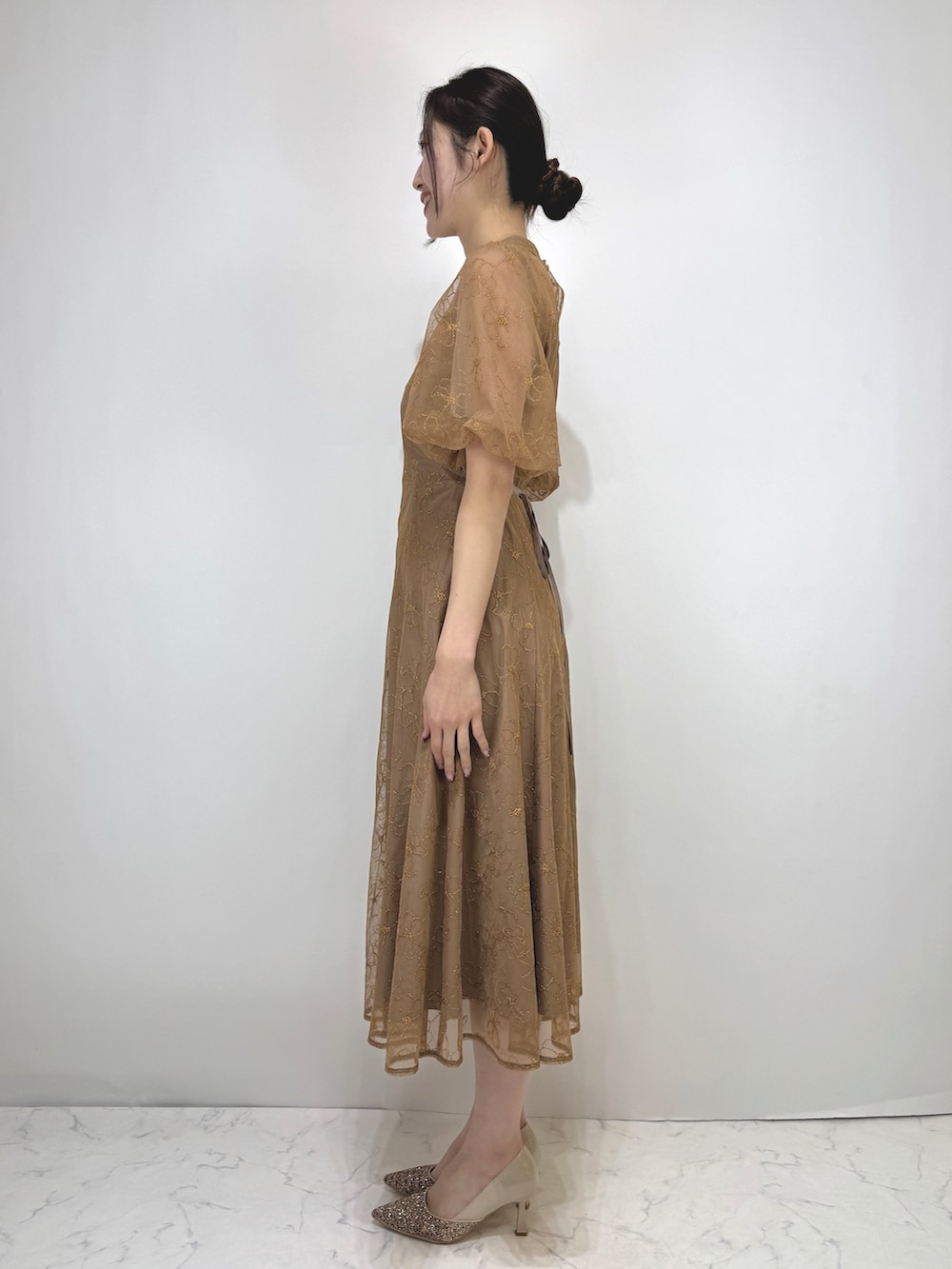 ブラウン系のドレス、ベージュ系のパンプスを着用したレディースの冬コーディネートの3枚目の写真