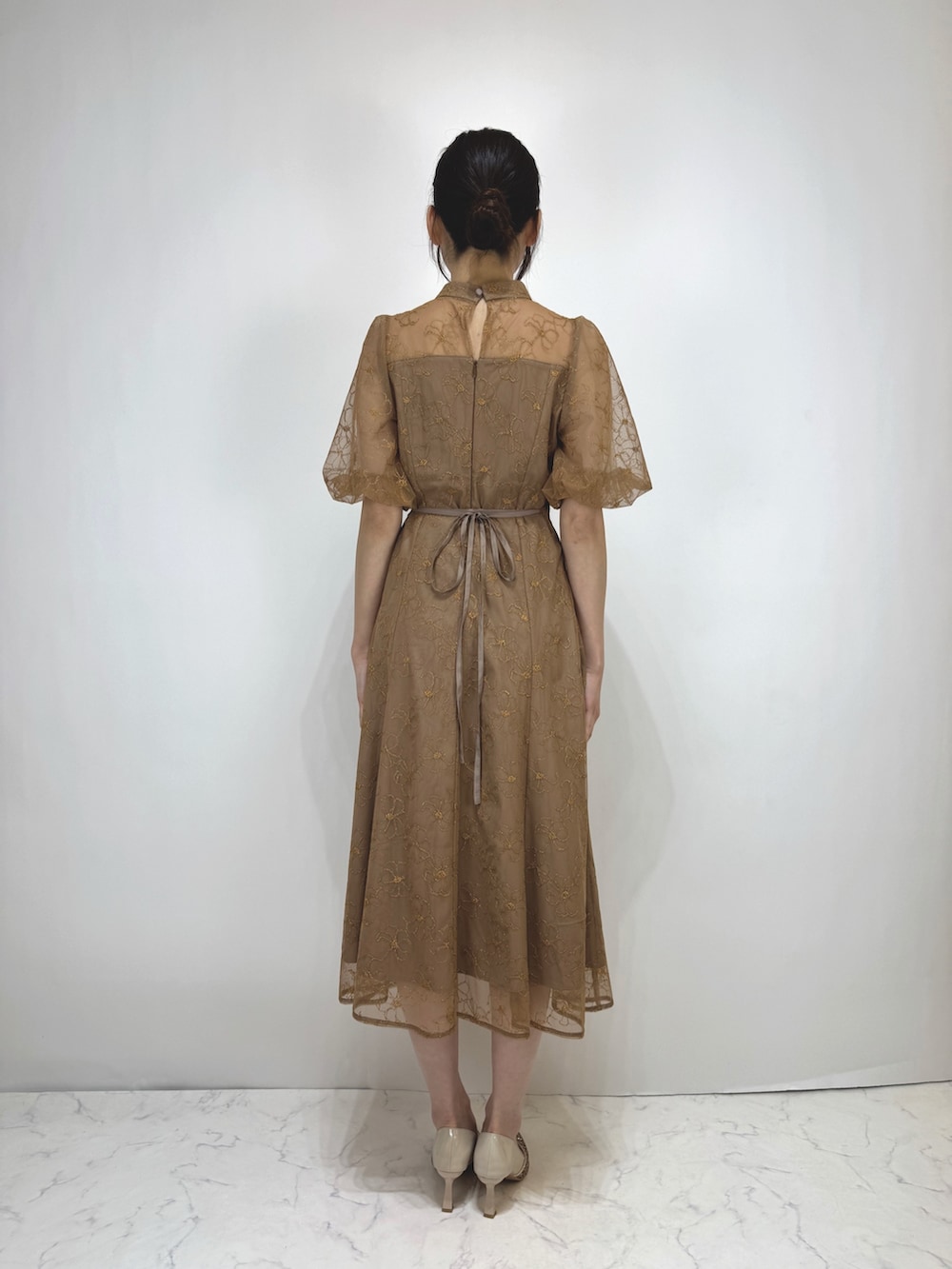 ブラウン系のドレス、ベージュ系のパンプスを着用したレディースの冬コーディネートの2枚目の写真