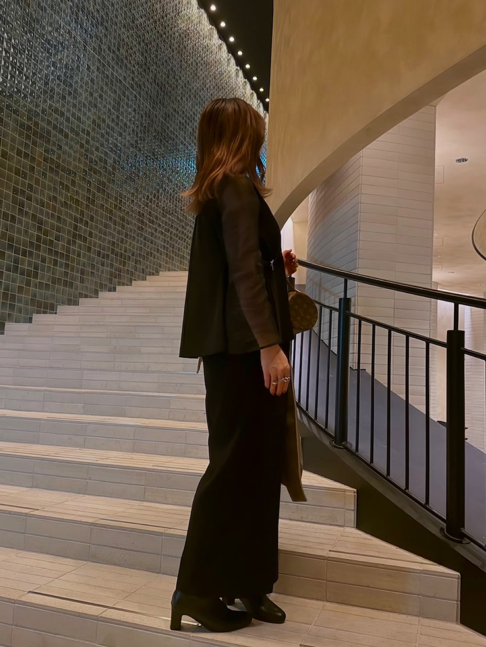 ブラック系のスーツセットを着用したレディースの冬コーディネートの2枚目の写真