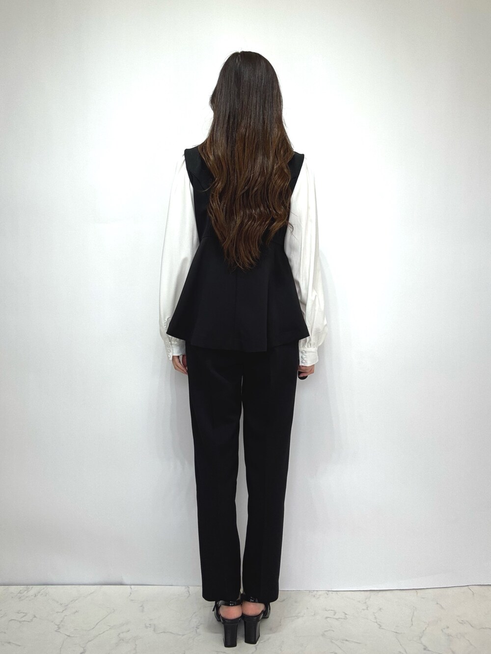 ブラック系のスーツセットを着用したレディースの冬コーディネートの3枚目の写真