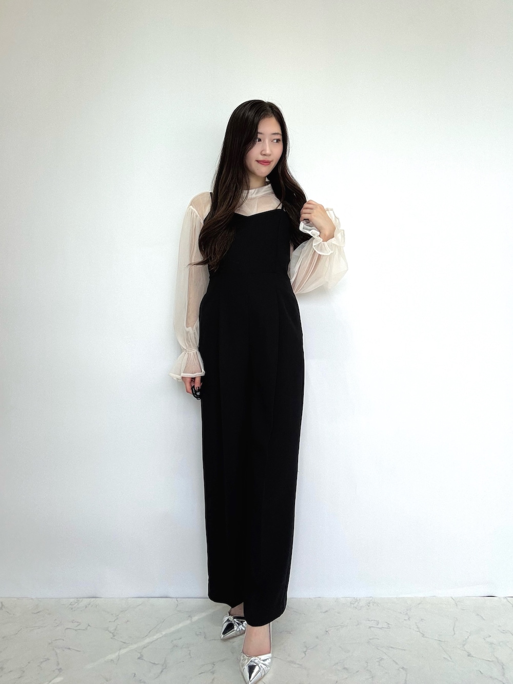 ブラック系のドレス、シルバー系のパンプス、ベージュ系のドレスを着用したレディースの秋コーディネートの6枚目の写真