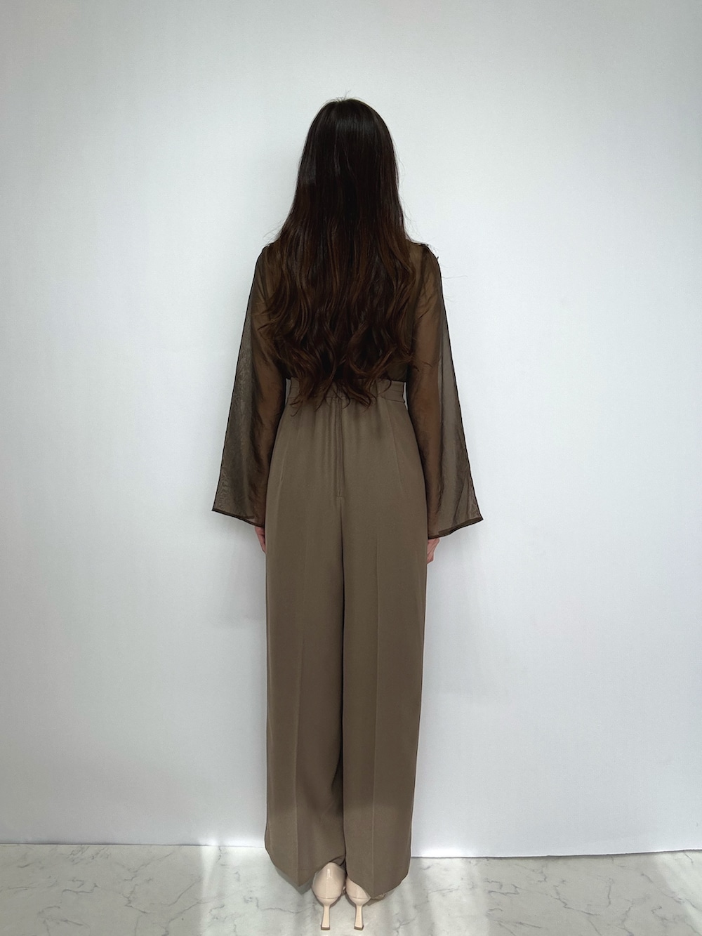 ブラウン系のスーツセット、ベージュ系のパンプスを着用したレディースの冬コーディネートの9枚目の写真