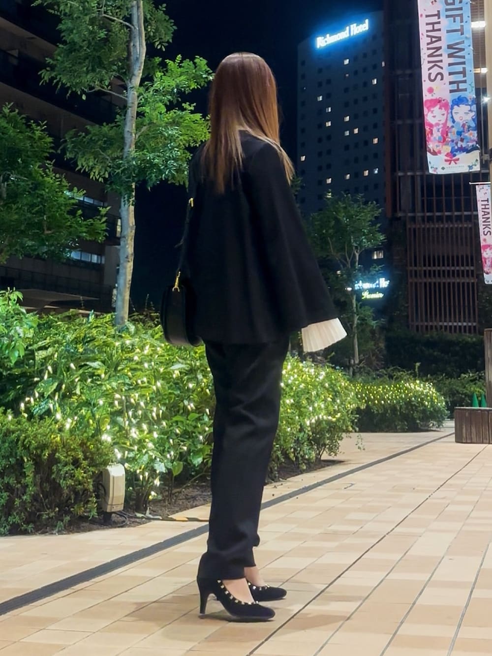 ブラック系のスーツセットを着用したレディースの冬コーディネートの7枚目の写真