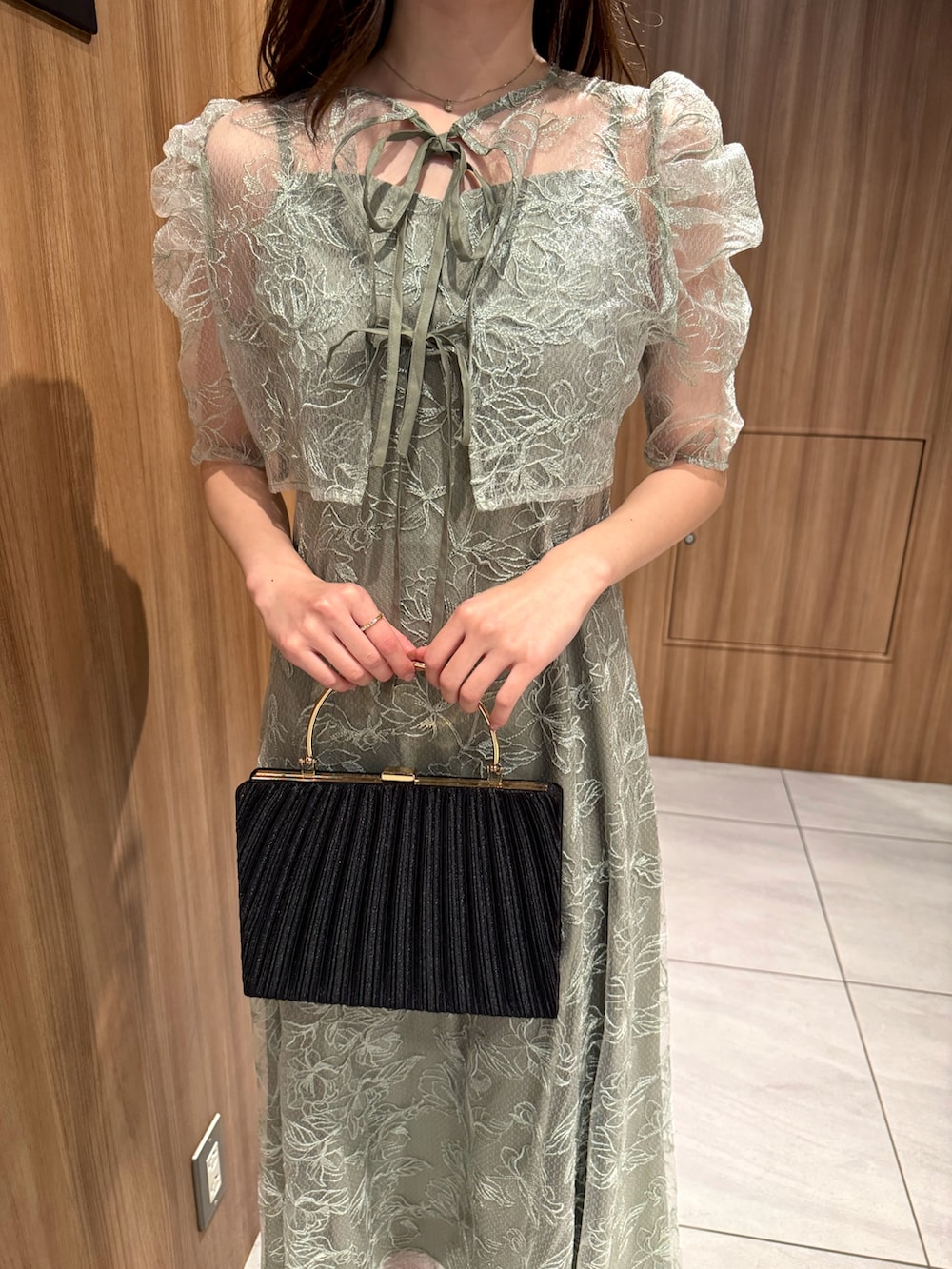 グリーン系のドレス、シルバー系のパンプスを着用したレディースの冬コーディネートの3枚目の写真