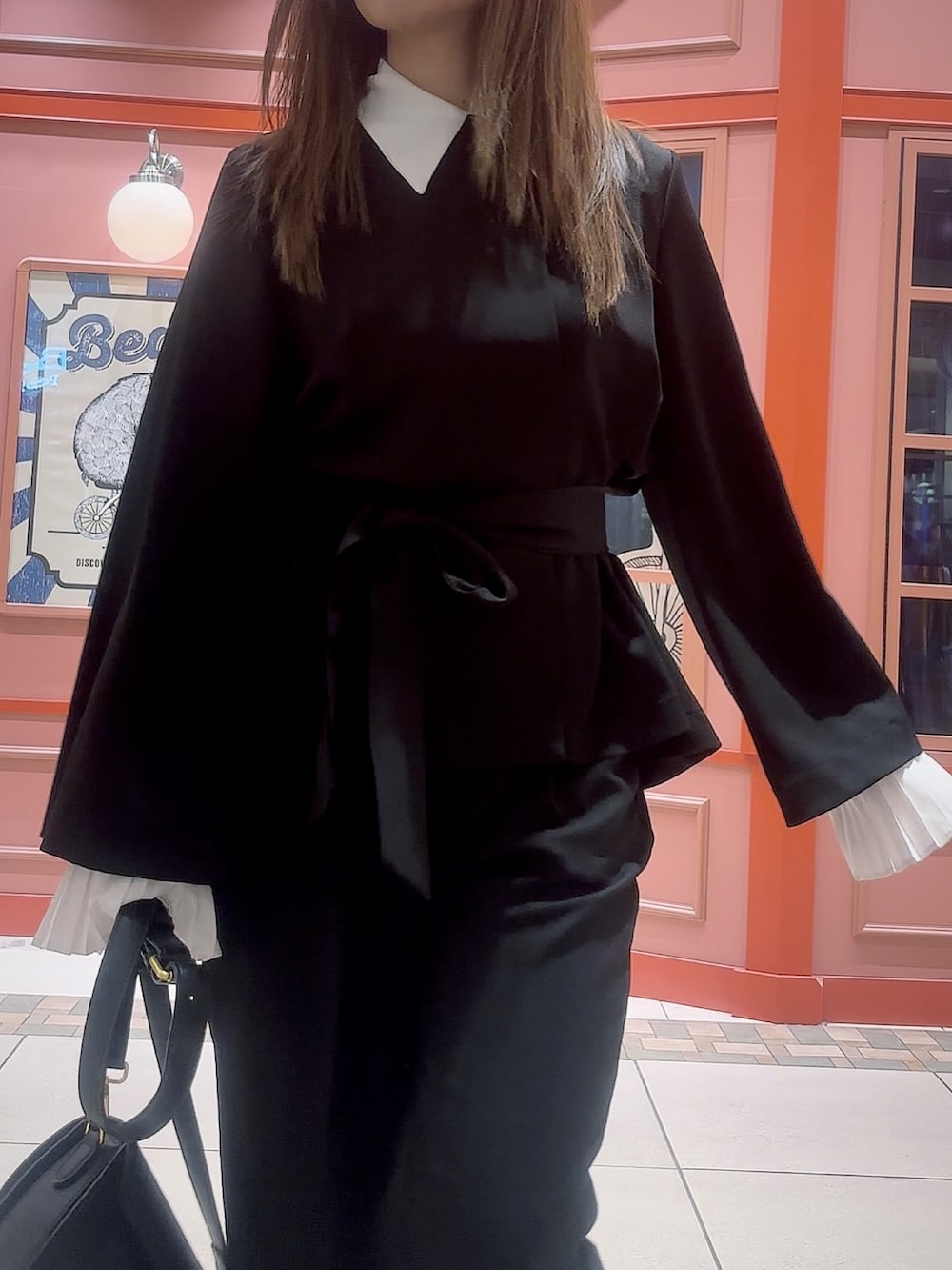 ブラック系のスーツセットを着用したレディースの冬コーディネートの6枚目の写真