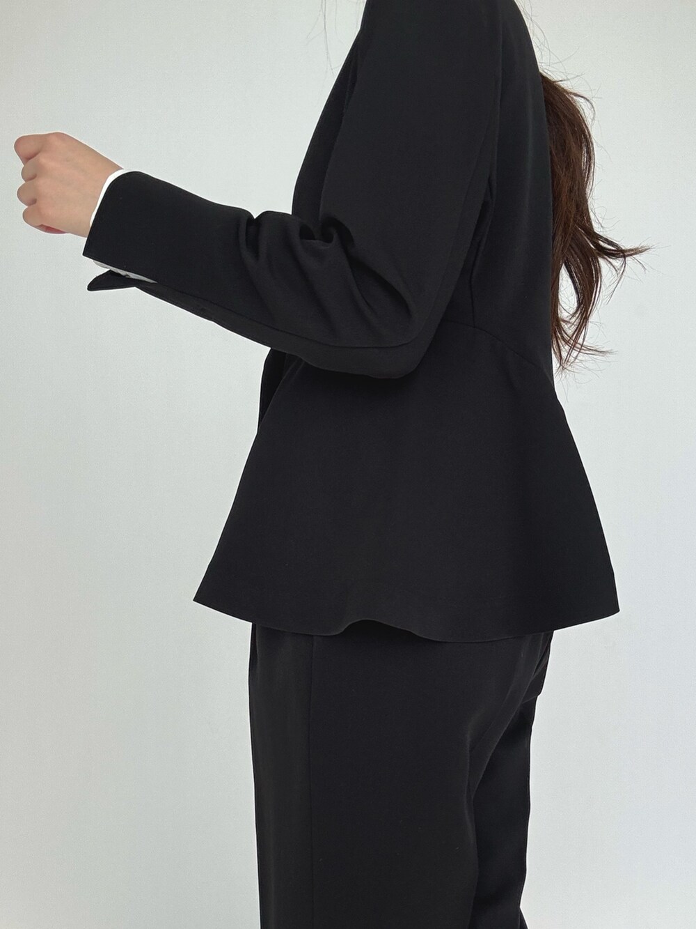 ブラック系のスーツセット、シルバー系のパンプスを着用したレディースの冬コーディネートの5枚目の写真