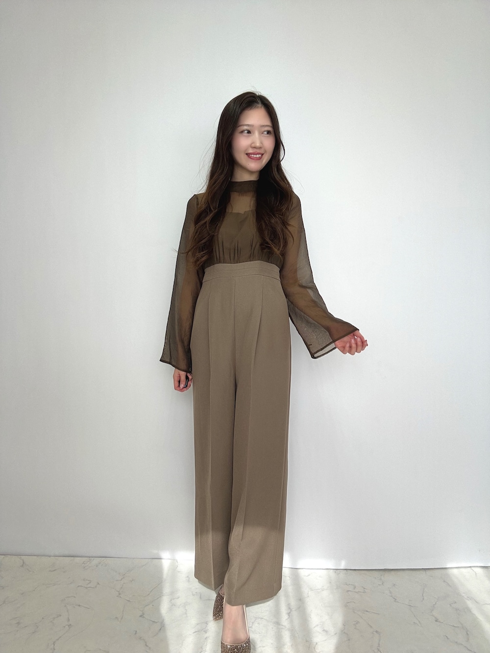 ブラウン系のスーツセット、ベージュ系のパンプスを着用したレディースの冬コーディネートの3枚目の写真