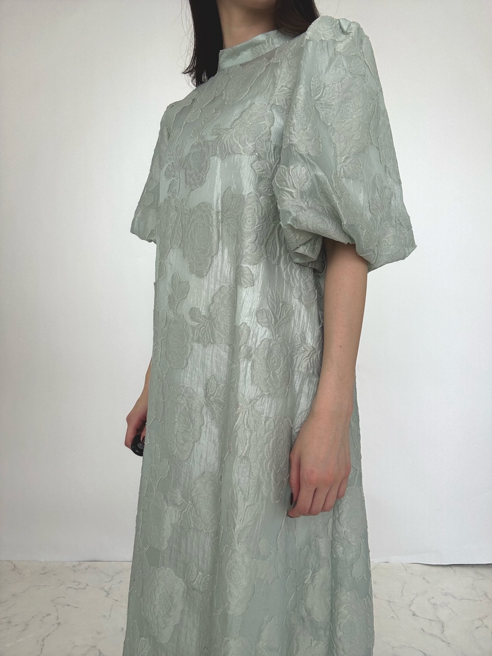 グリーン系のドレス、シルバー系のパンプスを着用したレディースの秋コーディネートの2枚目の写真