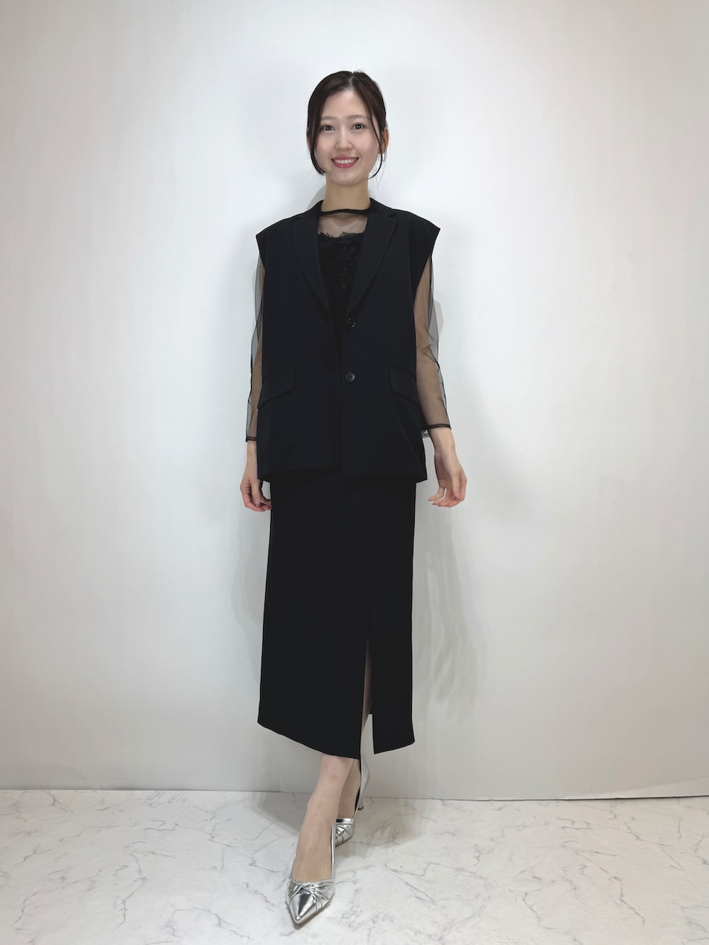 ブラック系のドレス、シルバー系のパンプスを着用したレディースの冬コーディネートの2枚目の写真