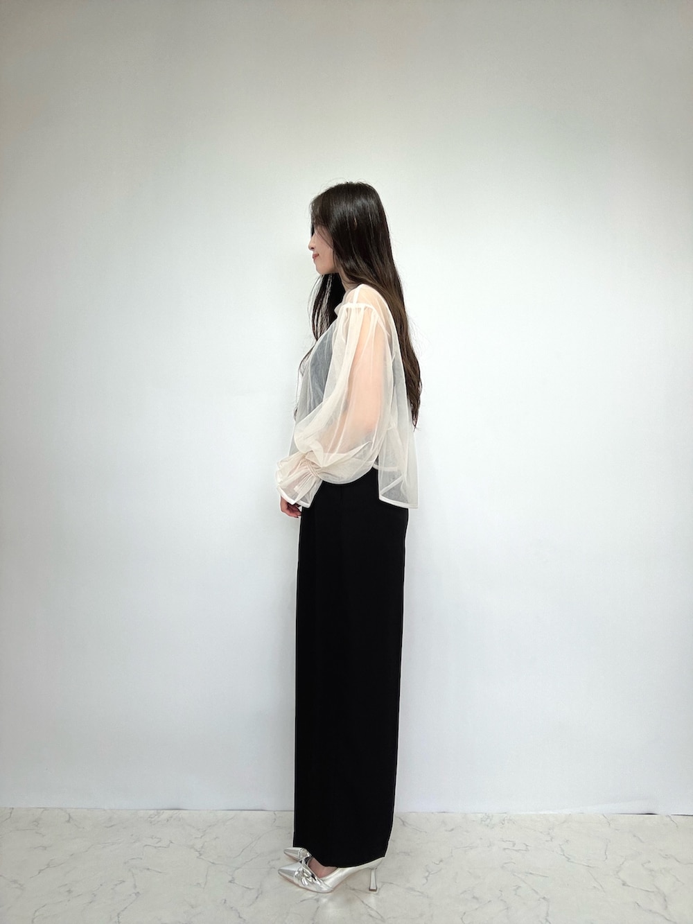 ブラック系のドレス、シルバー系のパンプス、ベージュ系のドレスを着用したレディースの秋コーディネートの2枚目の写真