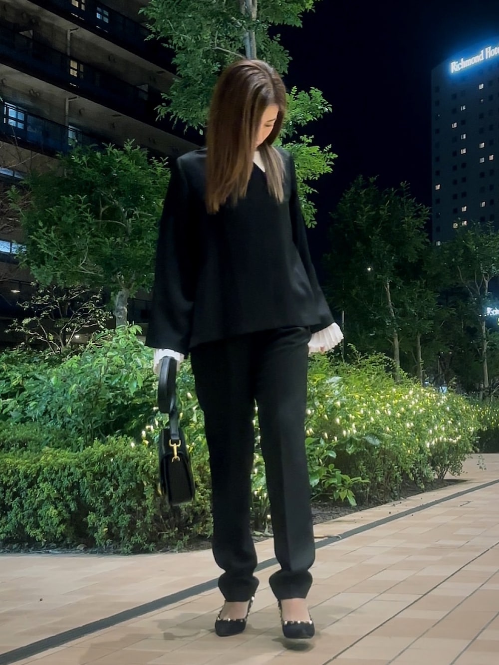 ブラック系のスーツセットを着用したレディースの冬コーディネートの2枚目の写真