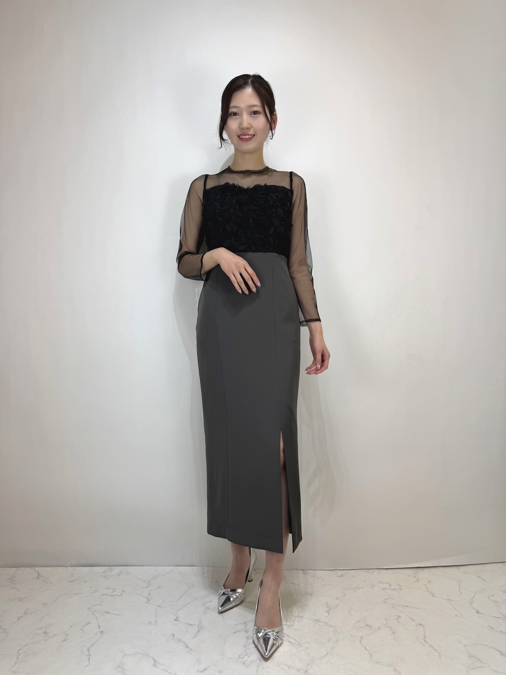 グレー系のドレス、シルバー系のパンプスを着用したレディースの冬コーディネートの2枚目の写真