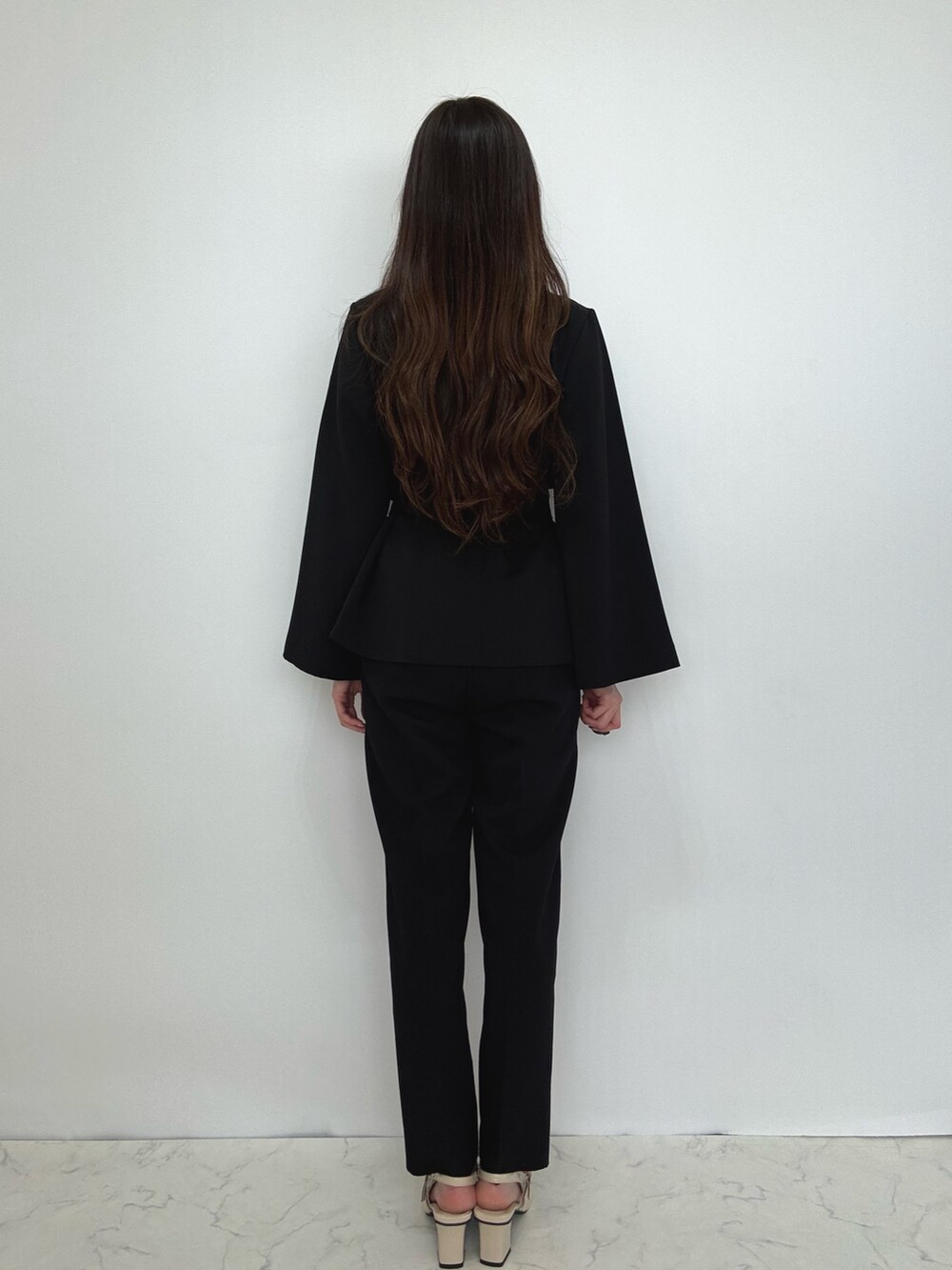 ブラック系のスーツセットを着用したレディースの冬コーディネートの4枚目の写真