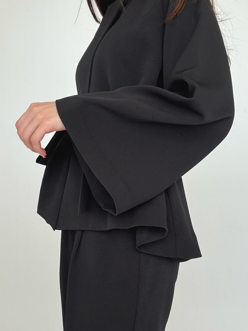 ブラック系のスーツセットを着用したレディースの冬コーディネートの2枚目の写真