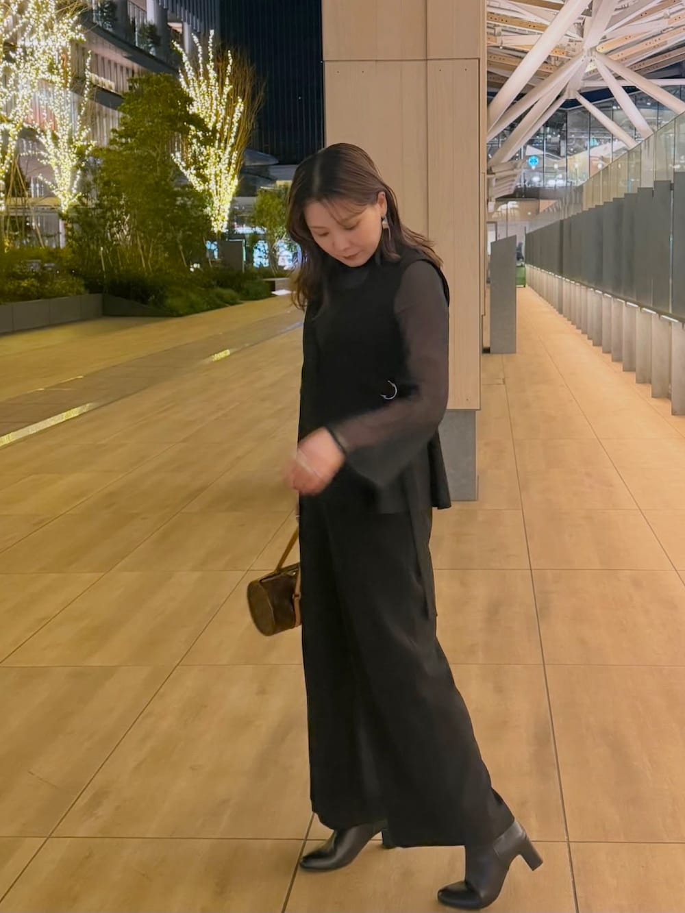 ブラック系のスーツセットを着用したレディースの冬コーディネートの4枚目の写真