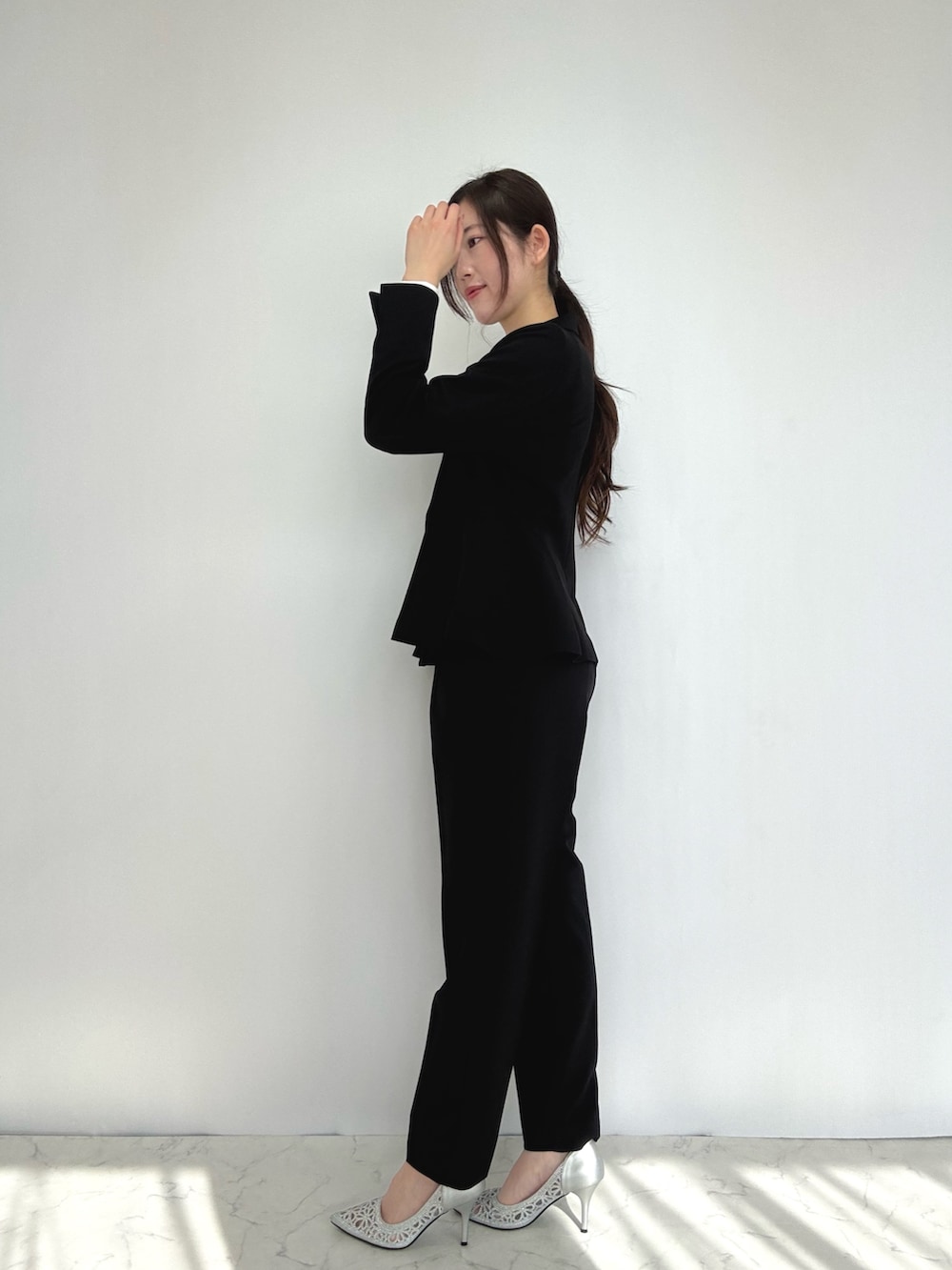 ブラック系のスーツセット、シルバー系のパンプスを着用したレディースの冬コーディネートの3枚目の写真