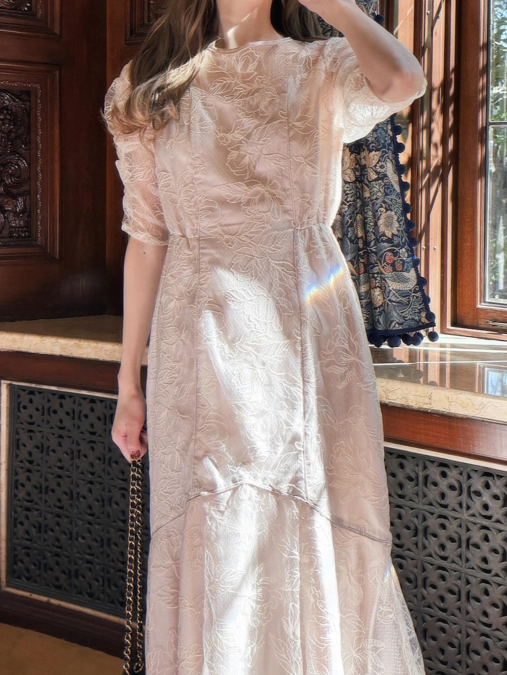 ベージュ系のドレスを着用したレディースの春コーディネートの2枚目の写真