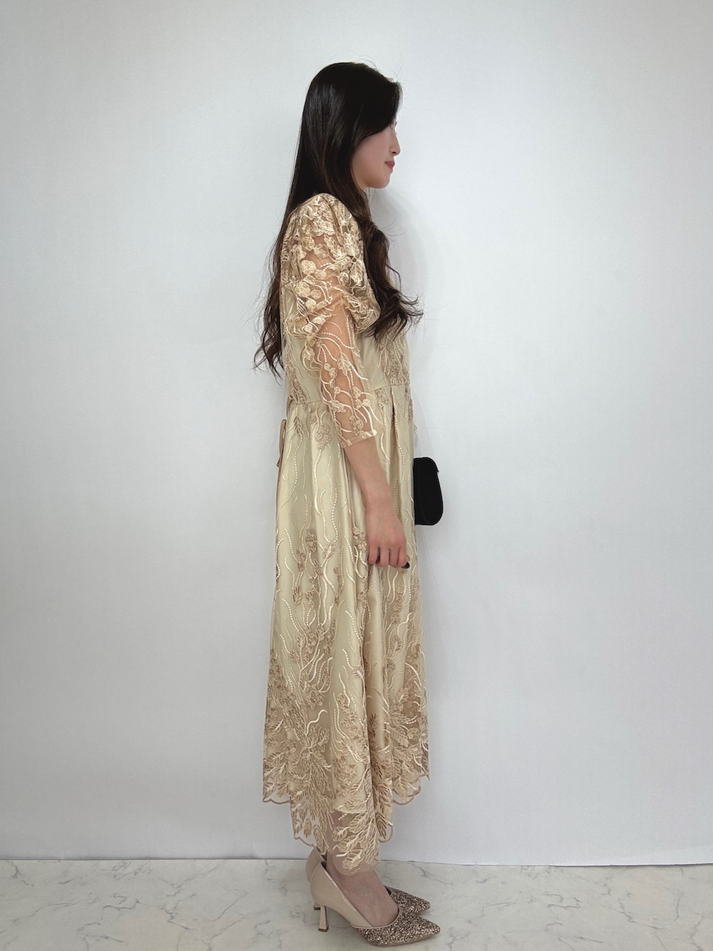 ベージュ系のドレス、ベージュ系のパンプスを着用したレディースの秋コーディネートの4枚目の写真