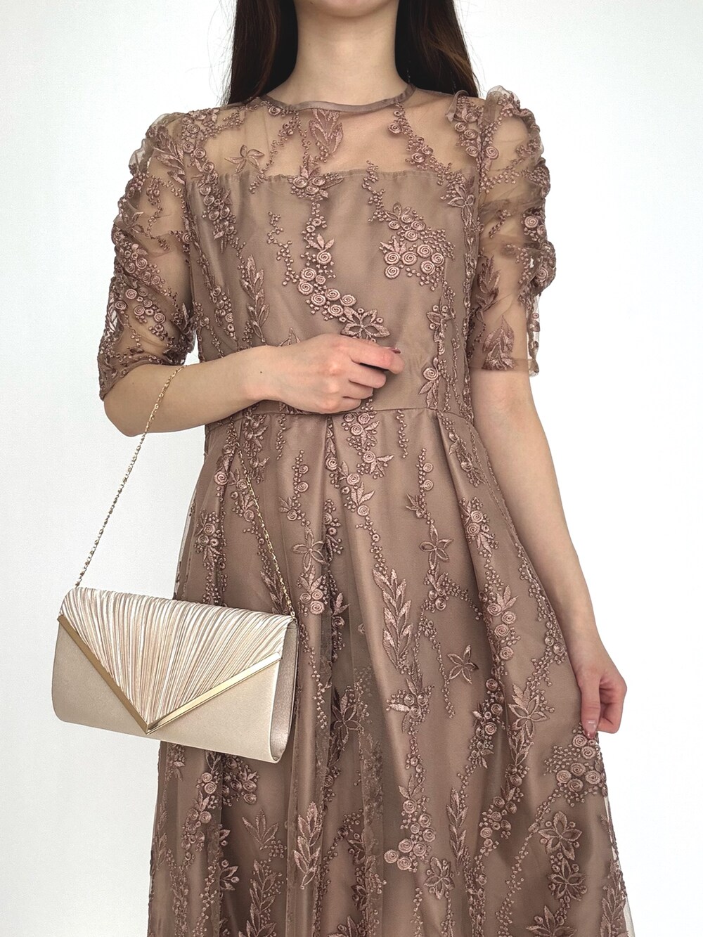 ベージュ系のクラッチバッグ、ブラウン系のドレスを着用したレディースの秋コーディネートの3枚目の写真