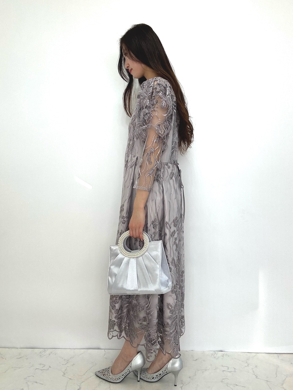 グレー系のドレス、シルバー系のパンプスを着用したレディースの秋コーディネートの5枚目の写真