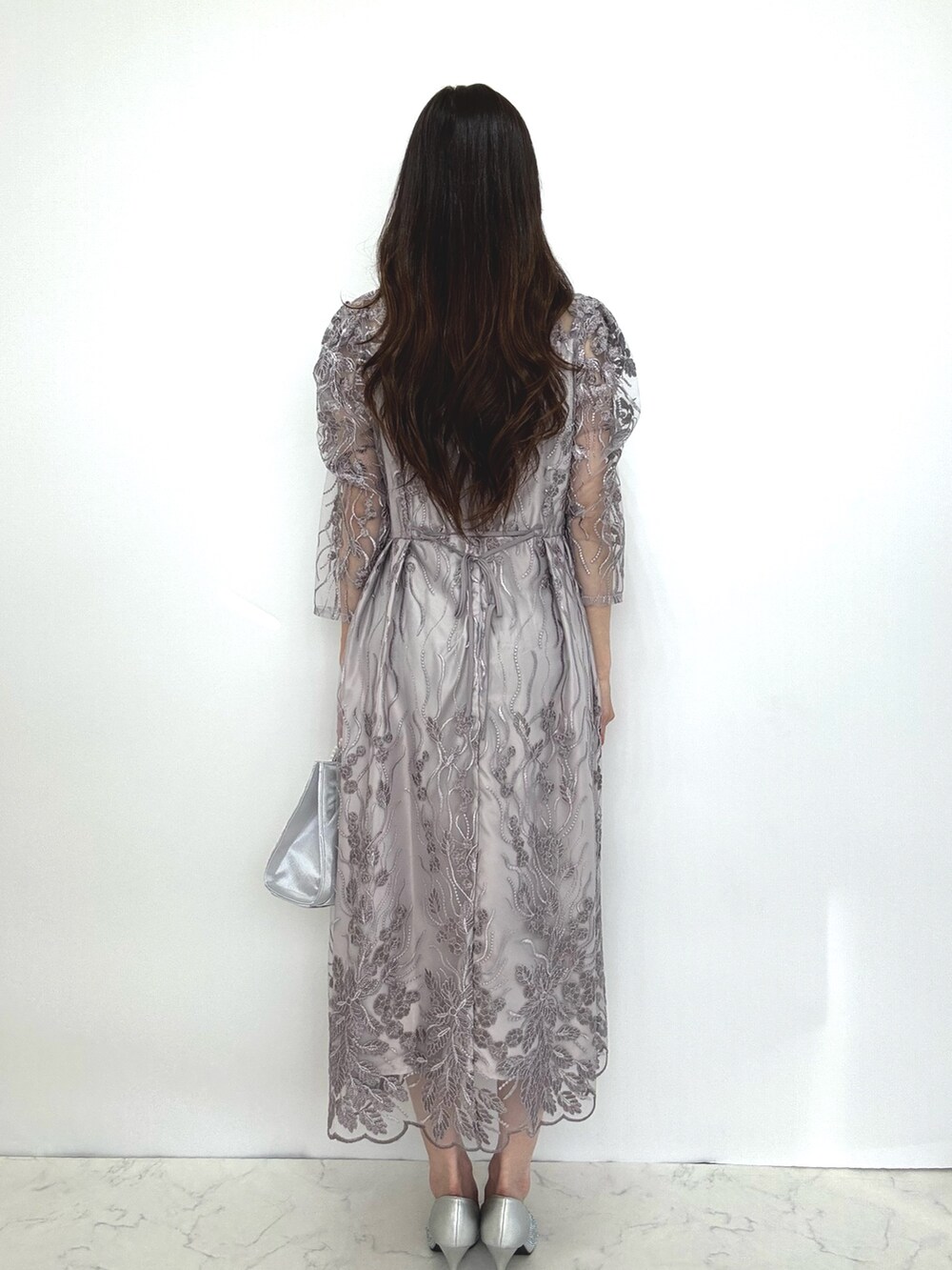 グレー系のドレス、シルバー系のパンプスを着用したレディースの秋コーディネートの4枚目の写真