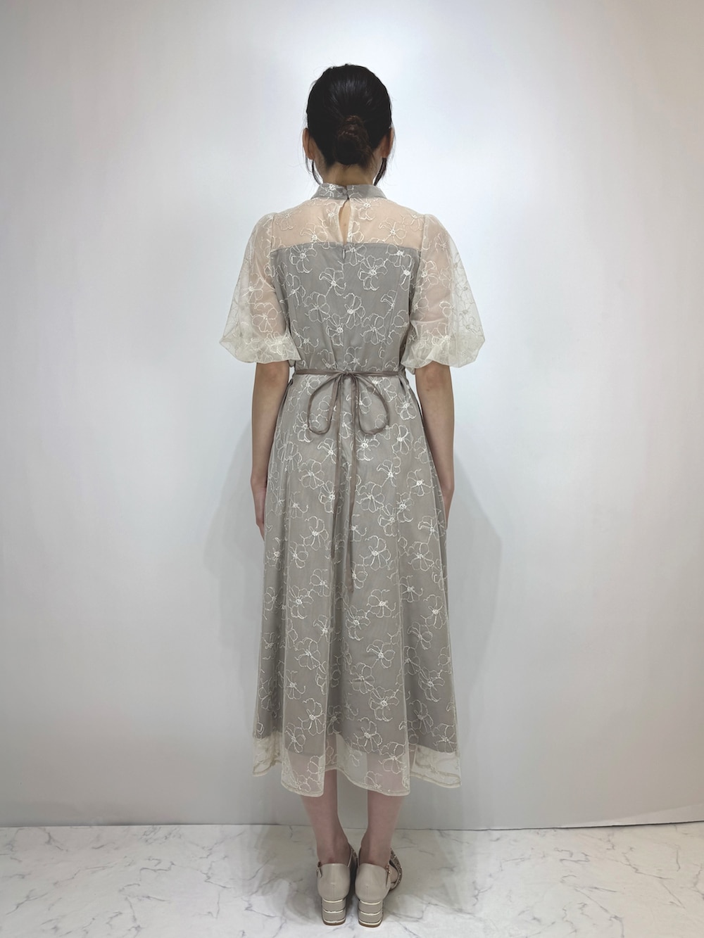 ベージュ系のドレス、ベージュ系のパンプスを着用したレディースの冬コーディネートの2枚目の写真