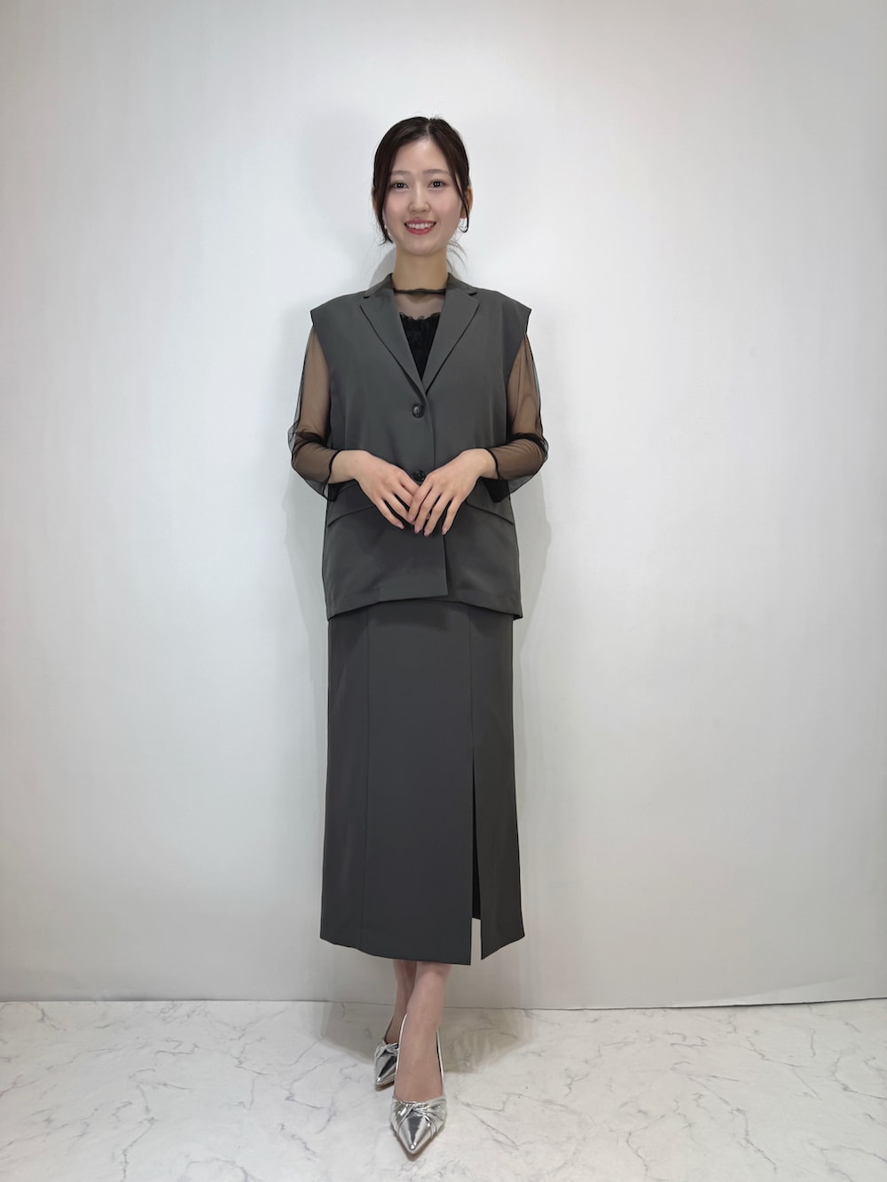 グレー系のドレス、シルバー系のパンプスを着用したレディースの冬コーディネートの3枚目の写真