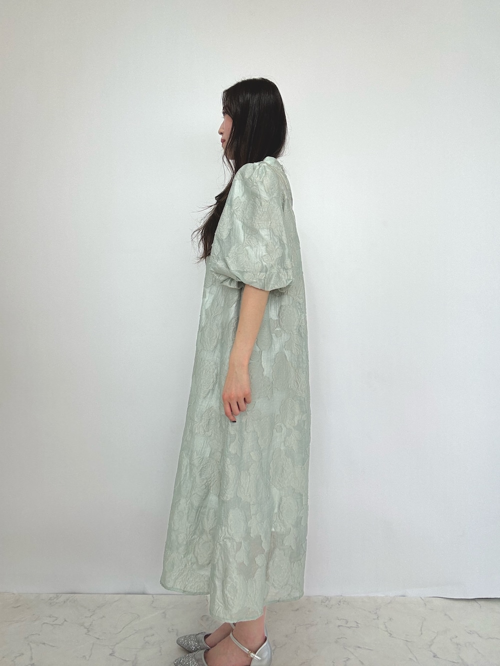 グリーン系のドレス、シルバー系のパンプスを着用したレディースの秋コーディネートの4枚目の写真