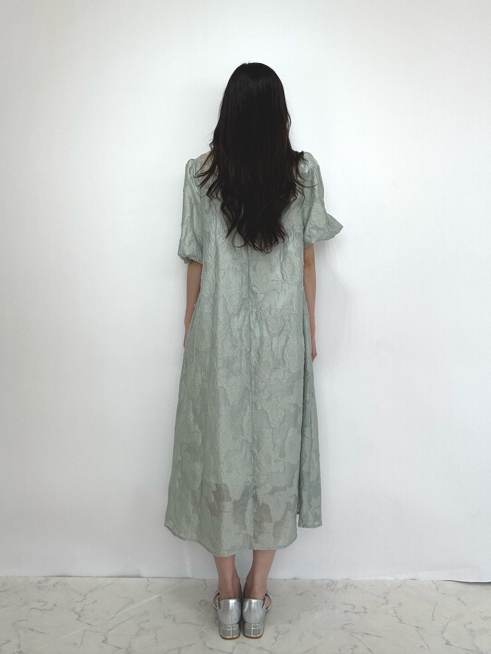 グリーン系のドレス、シルバー系のパンプスを着用したレディースの秋コーディネートの5枚目の写真