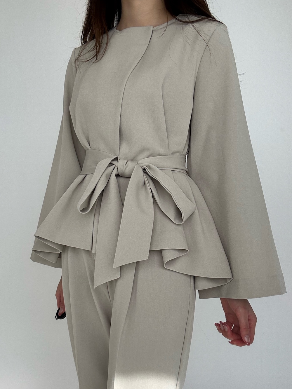 ベージュ系のスーツセットを着用したレディースの冬コーディネートの4枚目の写真