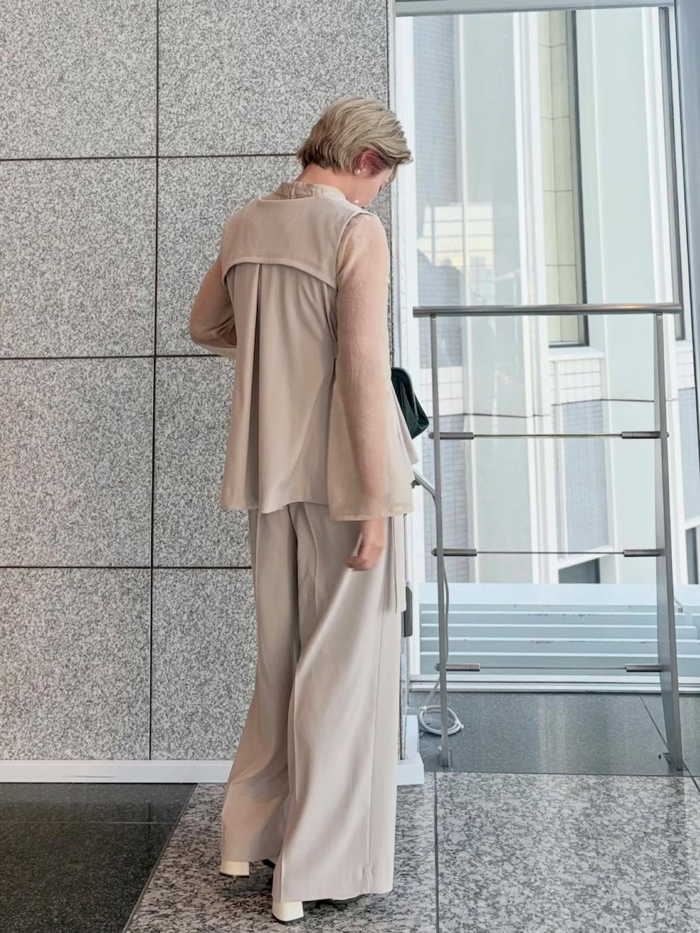 ベージュ系のスーツセットを着用したレディースの冬コーディネートの4枚目の写真