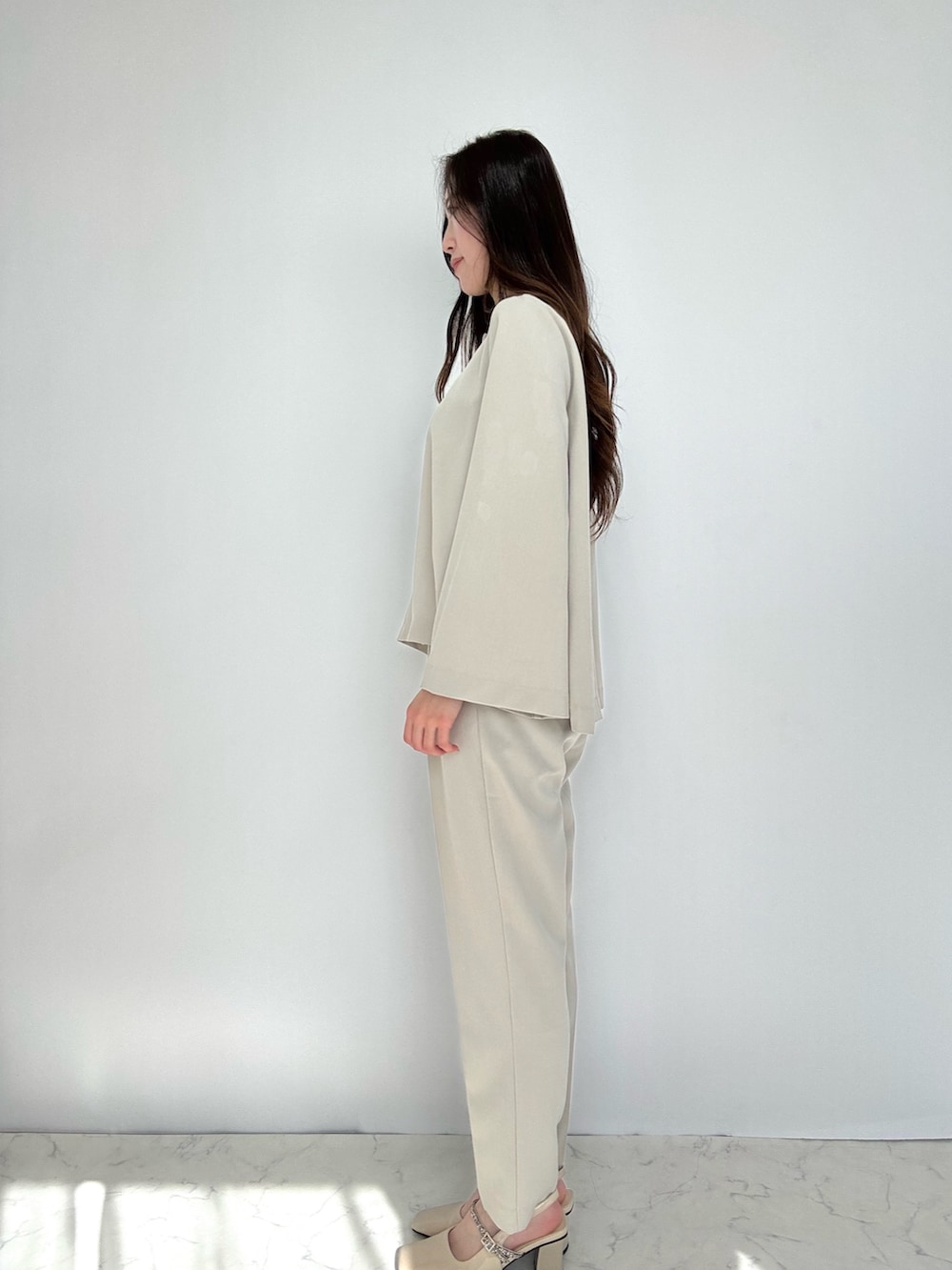 ベージュ系のスーツセットを着用したレディースの冬コーディネートの3枚目の写真