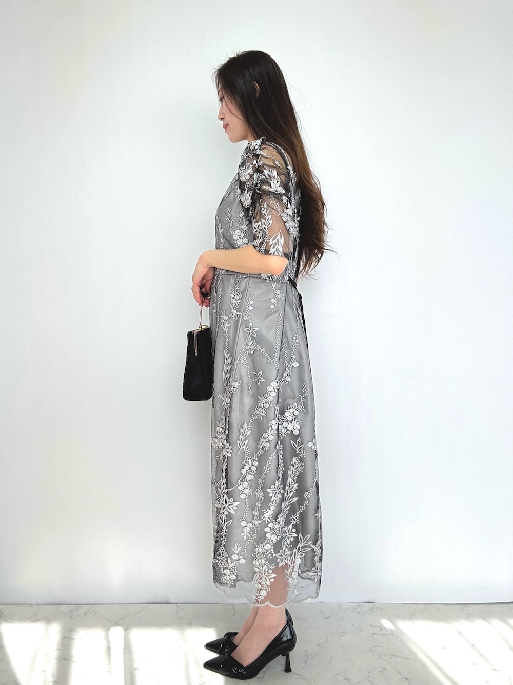 ブラック系のドレス、ブラック系のパンプスを着用したレディースの秋コーディネートの2枚目の写真