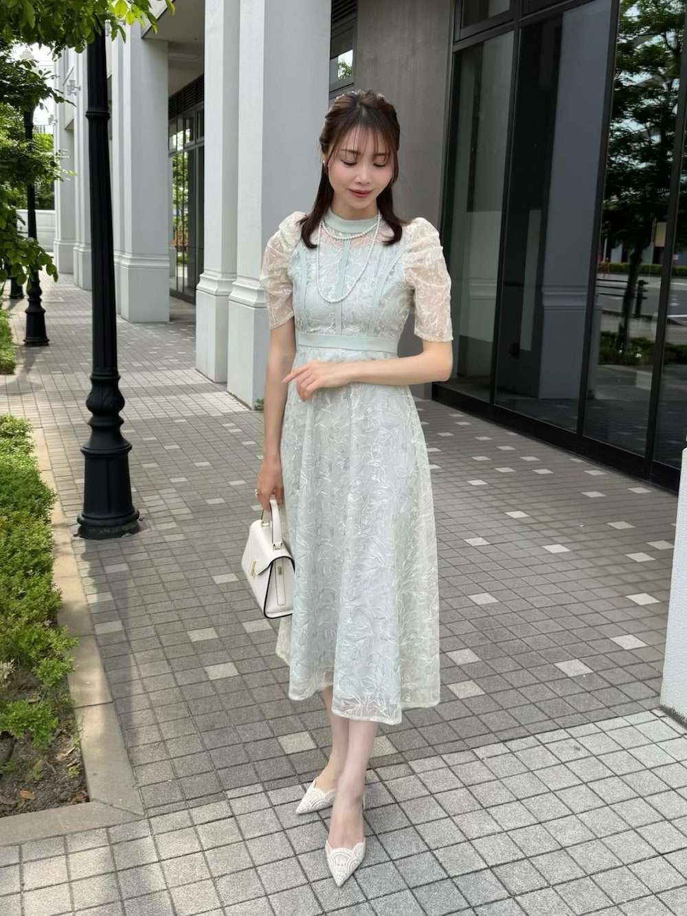 グリーン系のドレスを着用したレディースの夏コーディネートの2枚目の写真