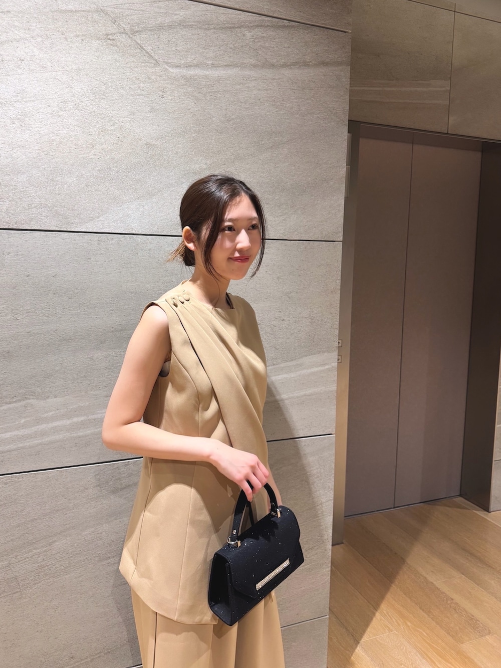 ベージュ系のスーツセットを着用したレディースの冬コーディネートの2枚目の写真