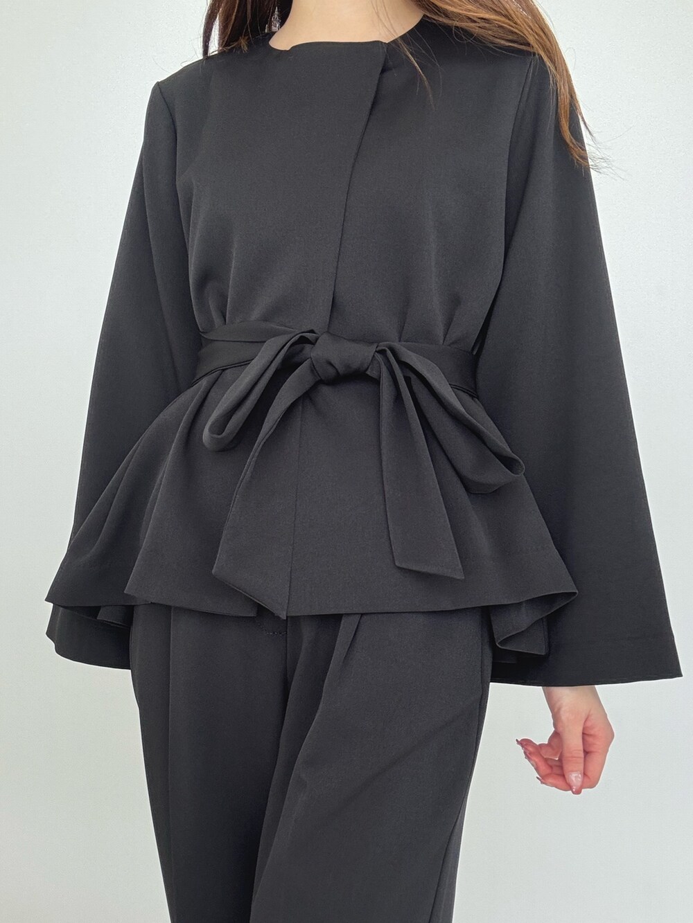 ブラック系のスーツセットを着用したレディースの冬コーディネートの3枚目の写真