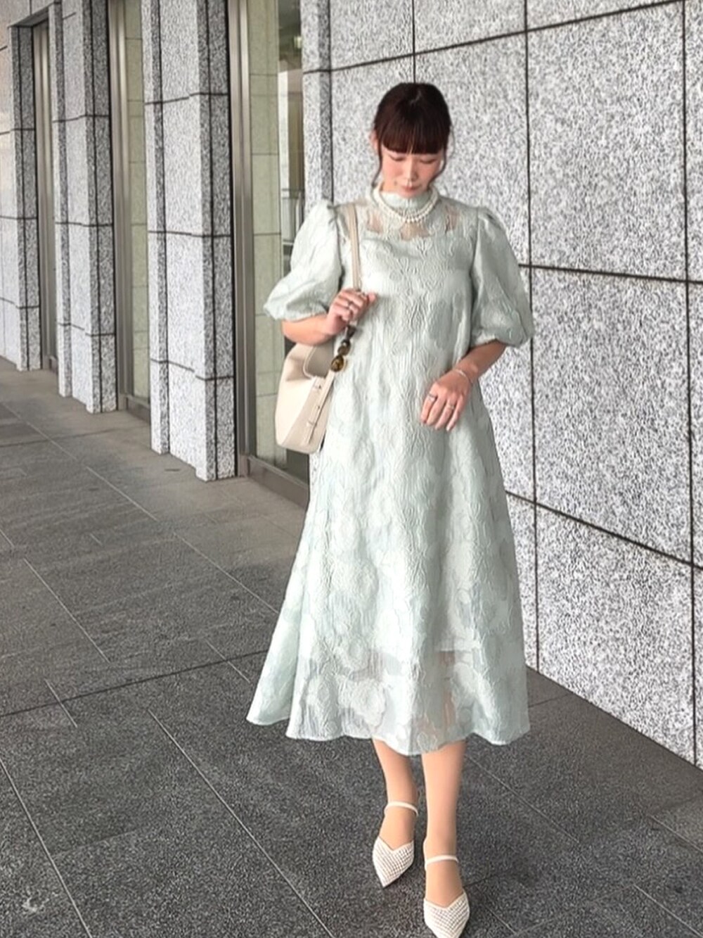 グリーン系のドレスを着用したレディースの春コーディネートの4枚目の写真