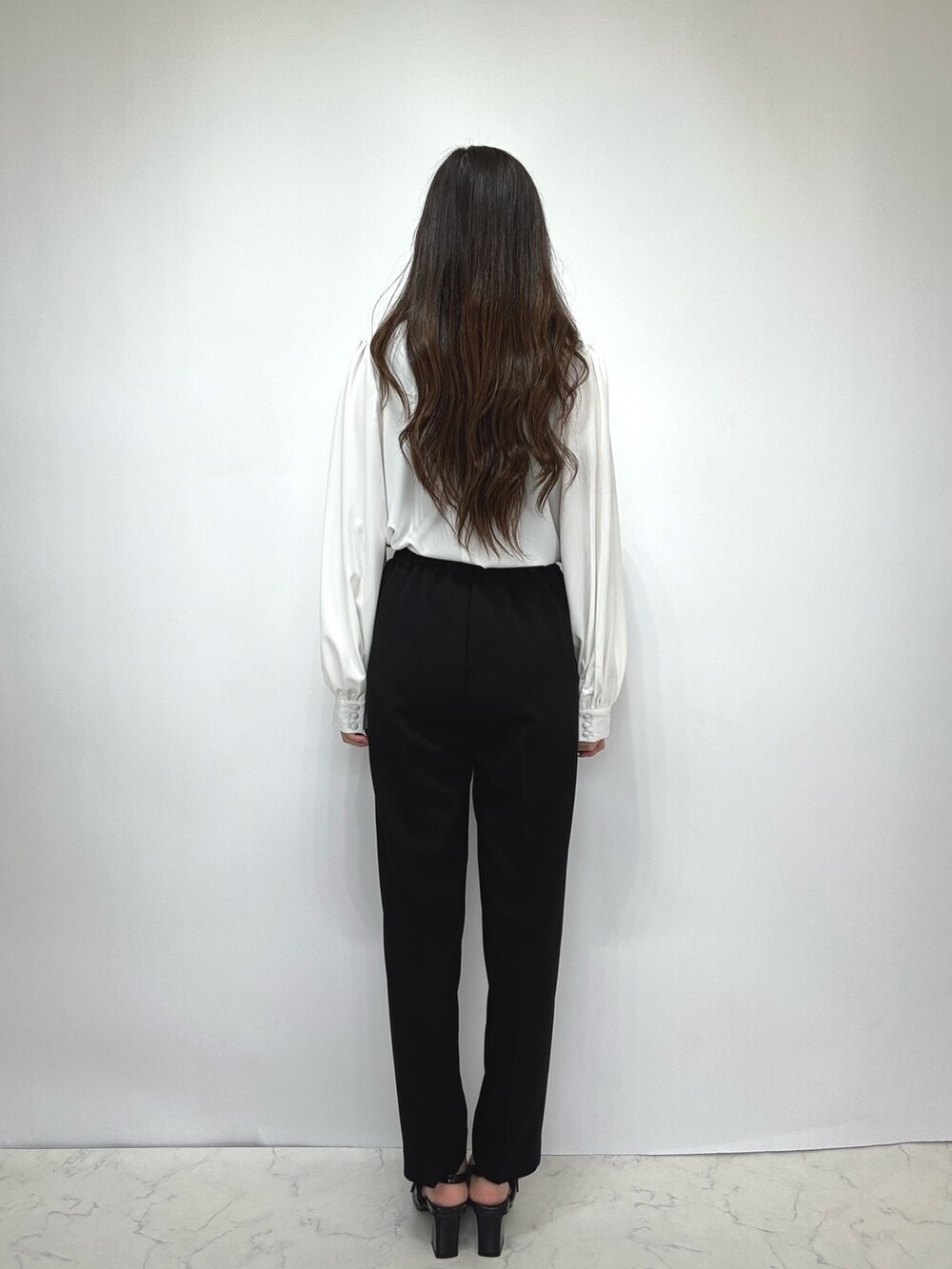 ブラック系のスーツセットを着用したレディースの冬コーディネートの6枚目の写真