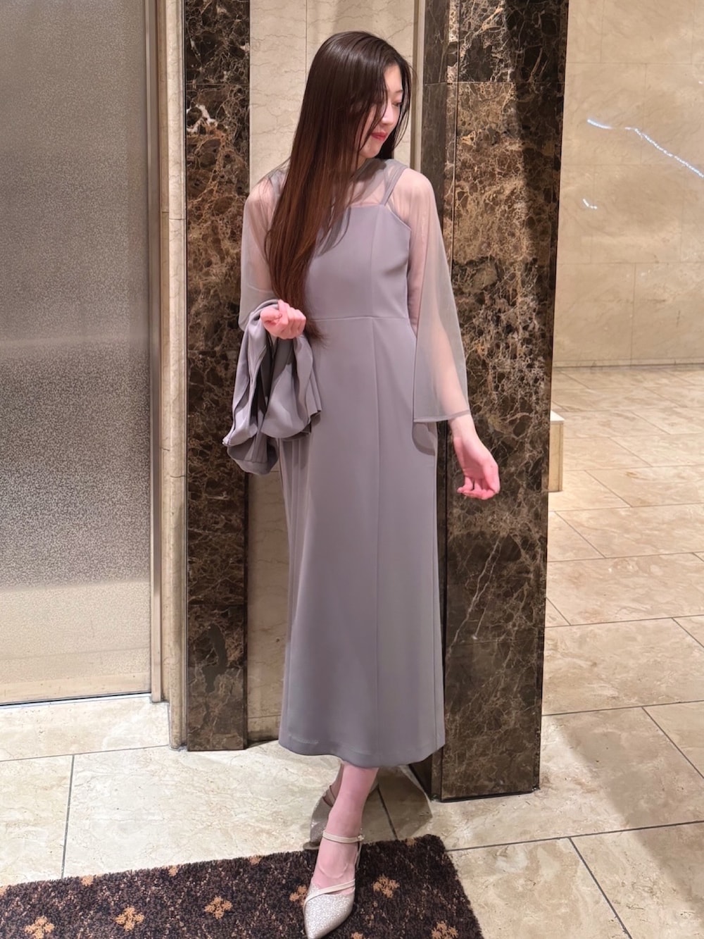 ベージュ系のドレス、ベージュ系のパンプスを着用したレディースの冬コーディネートの2枚目の写真