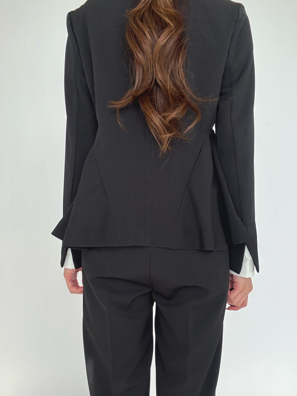 ブラック系のスーツセット、シルバー系のパンプスを着用したレディースの冬コーディネートの6枚目の写真